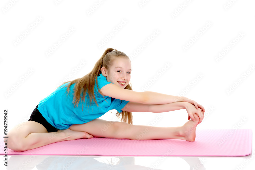The little gymnast perform an acrobatic element on the floor. The little gymnast perform an acrobatic element on the floor.