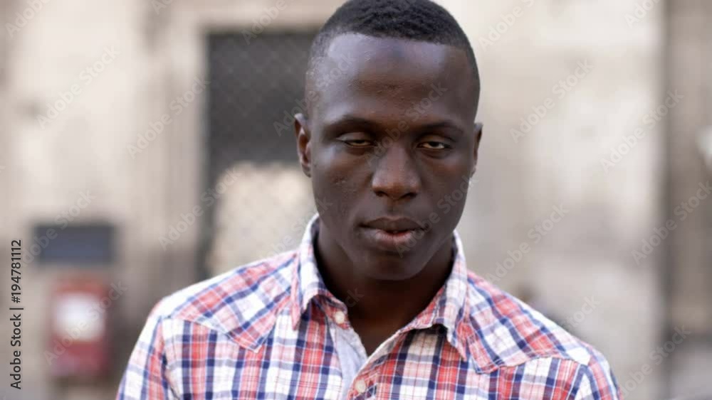 Serious black man in the street staring at camera Serious black man in the street staring at camera