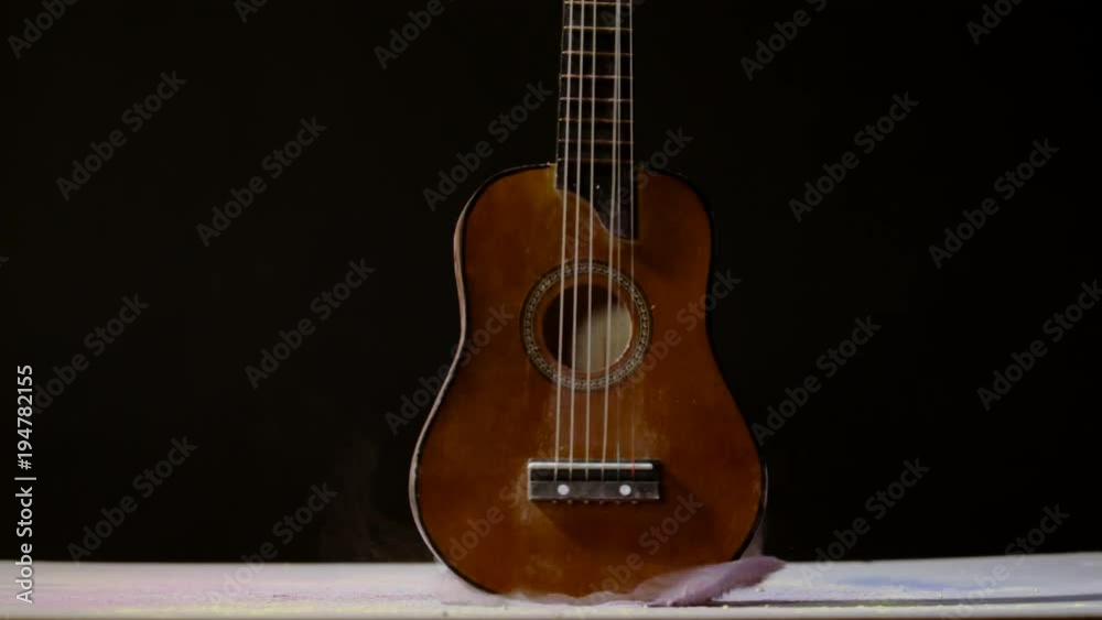 Guitar rotating and falling in dust, Ultra Slow Motion Guitar rotating and falling in dust, Ultra Slow Motion