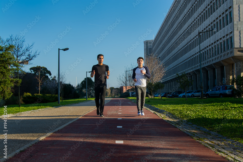 two young man in sport clothes running two young man in sport clothes running