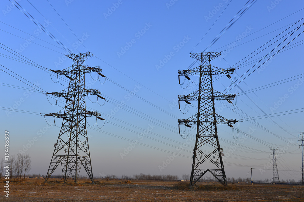Fototapeta premium The silhouette of the evening electricity transmission pylon