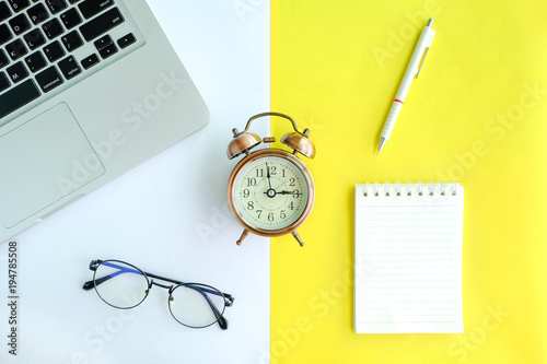 Workspace desk with Laptop, Note book , Glasses and Clock. Lifestyle modern background.Top view photo