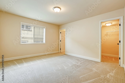 Light empty bedroom interior in beige tones