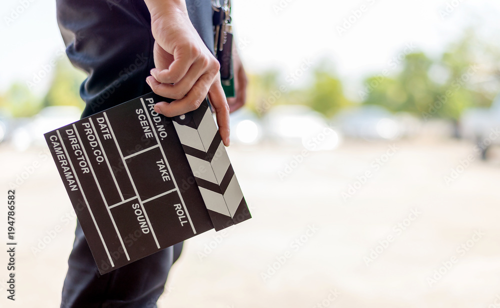 Fototapeta premium closeup man hands holding film clapper with soft-focus and over light in the background
