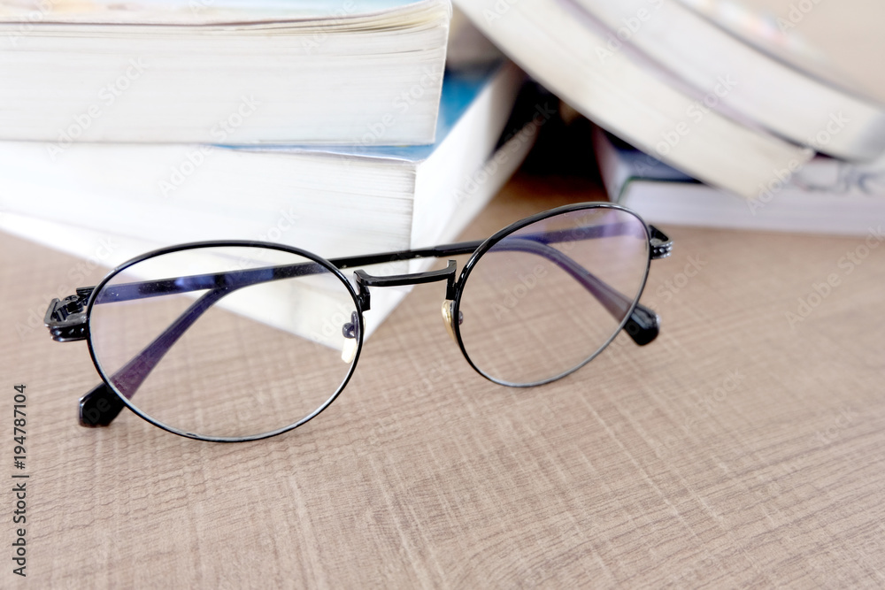Glasses and books placed on table in the livingroom .Colorful background.Educational Ideas Glasses and books placed on table in the livingroom .Colorful background.Educational Ideas