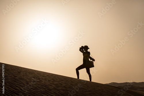 Canvas Print Young tourist in shorts hiking in giant dunes.