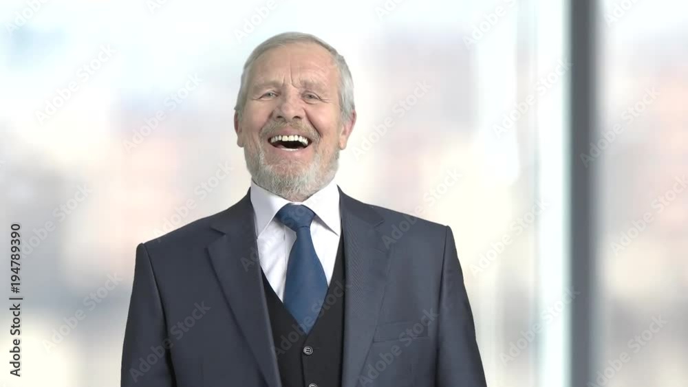 Elderly laughing entrepreneur, slow motion. Joyful senior man in formal wear, blurred background. Human facial expression. Elderly laughing entrepreneur, slow motion. Joyful senior man in formal wear, blurred background. Human facial expression.