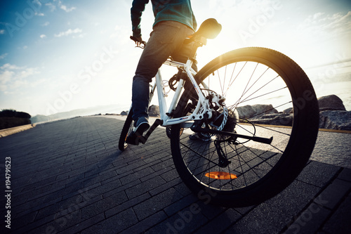 cyclist riding bike in the sunrise coast path © lzf