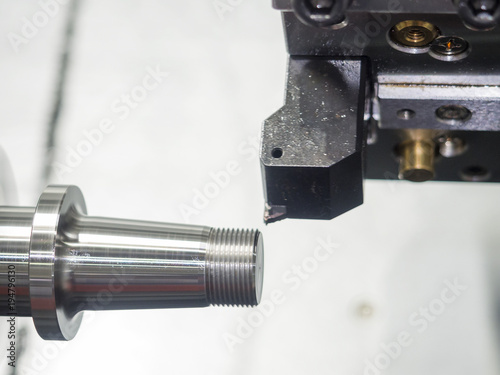 Operator machining automotive part by cnc turning machine,