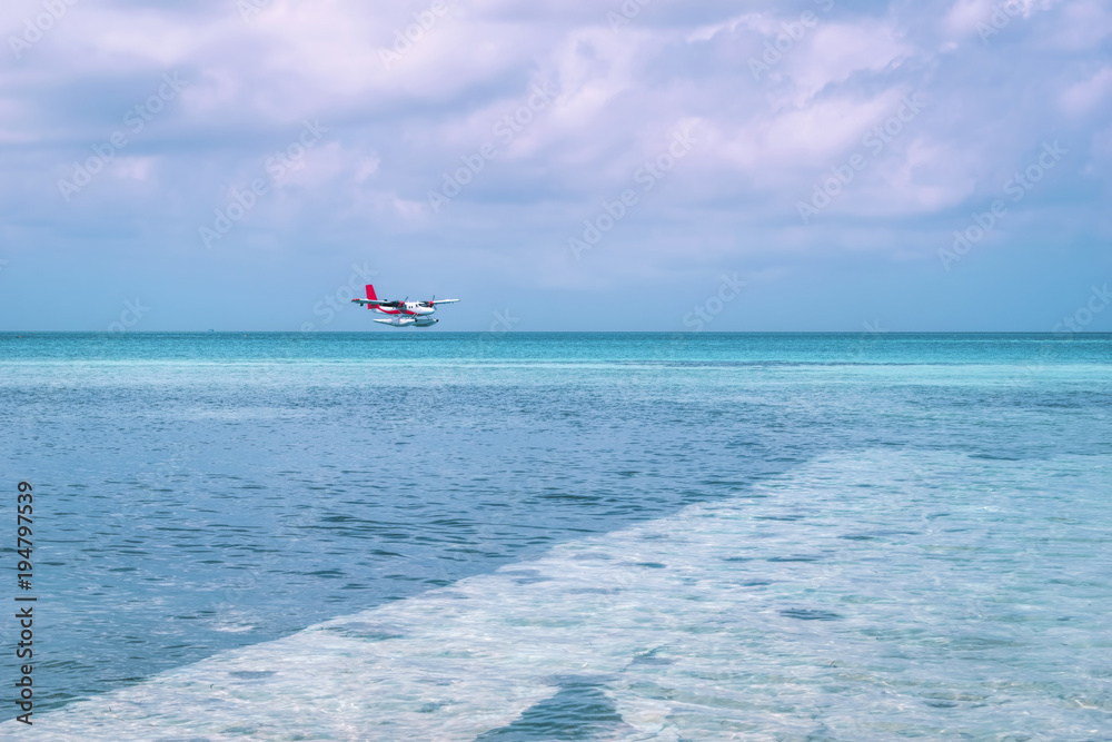 Seaplane landing at beautiful Maldives island beach