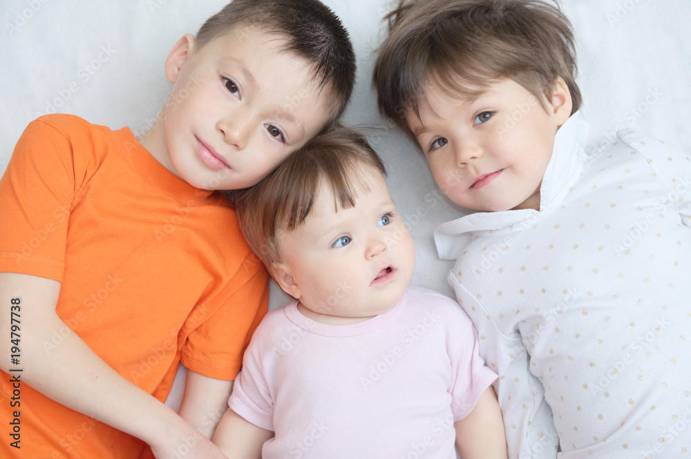 happy kids, three laughing children different ages lying, portrait of boy, little girl and baby girl, happiness in childhood of siblings, living in big family with three children happy kids, three laughing children different ages lying, portrait of boy, little girl and baby girl, happiness in childhood of siblings, living in big family with three children