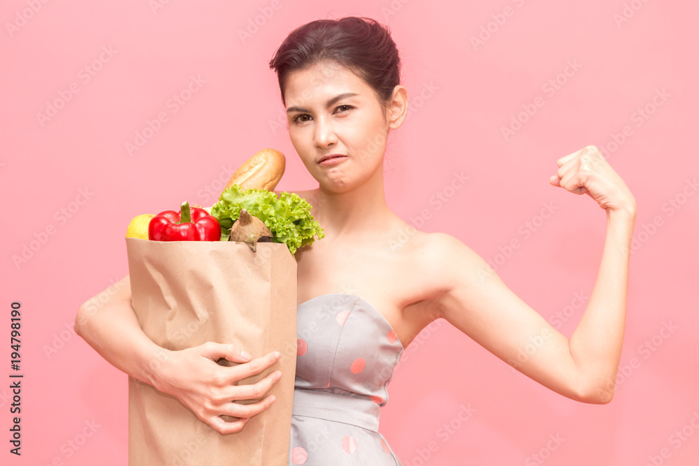 Woman holding shopping paper bag with fruit and vegetables diet healthy eating on pink background Woman holding shopping paper bag with fruit and vegetables diet healthy eating on pink background
