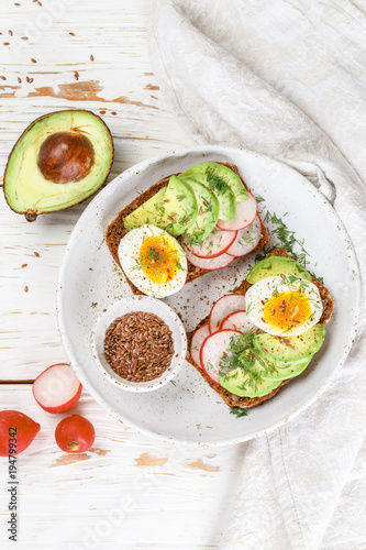 Toast with avocado, radish, egg and flax seeds