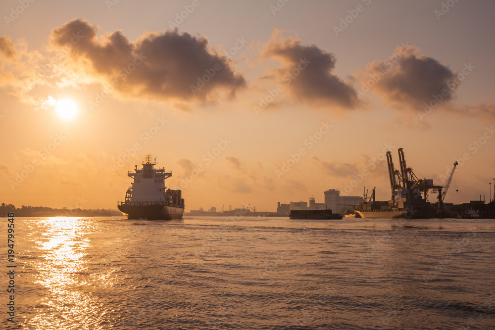 Cargo ship is sailing out of the harbor at evening to sea to transport cargo in the container.Logistics and transportation of International, Freight Transportation, Shipping