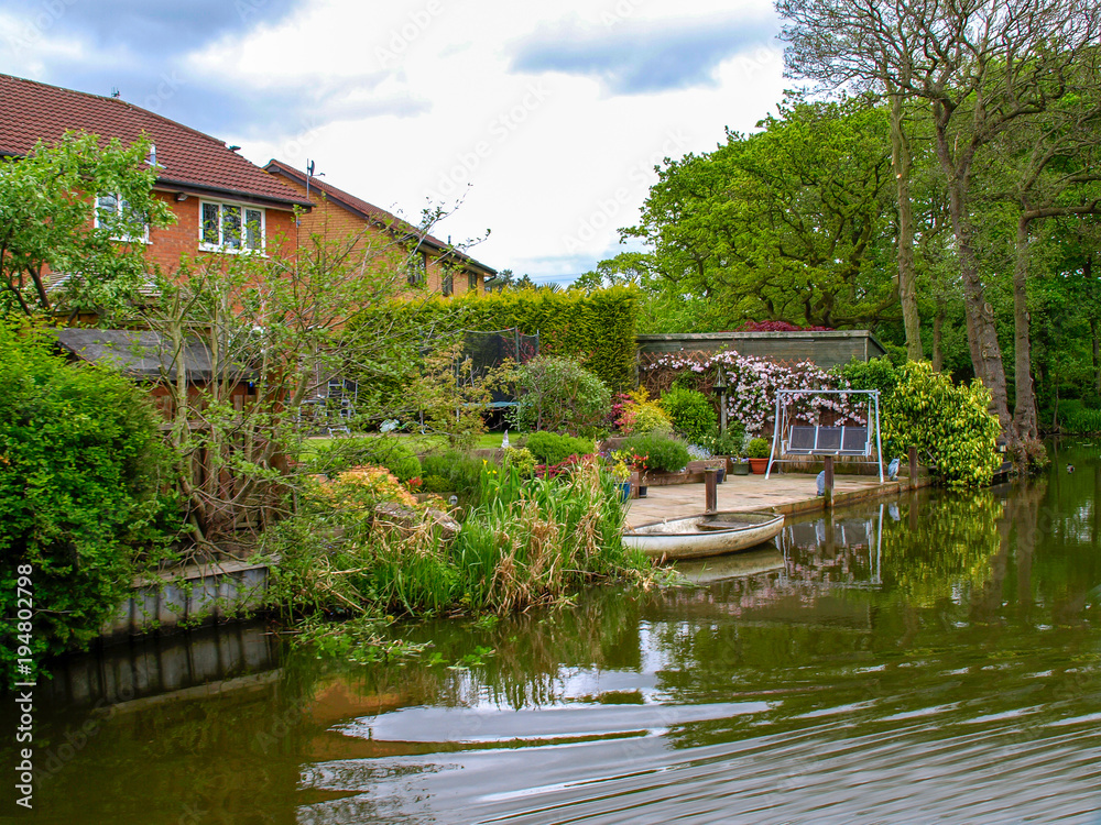 Obraz premium Canalside house on the Trent and Mersey Canal in the West Midlands in England. View from the boat.