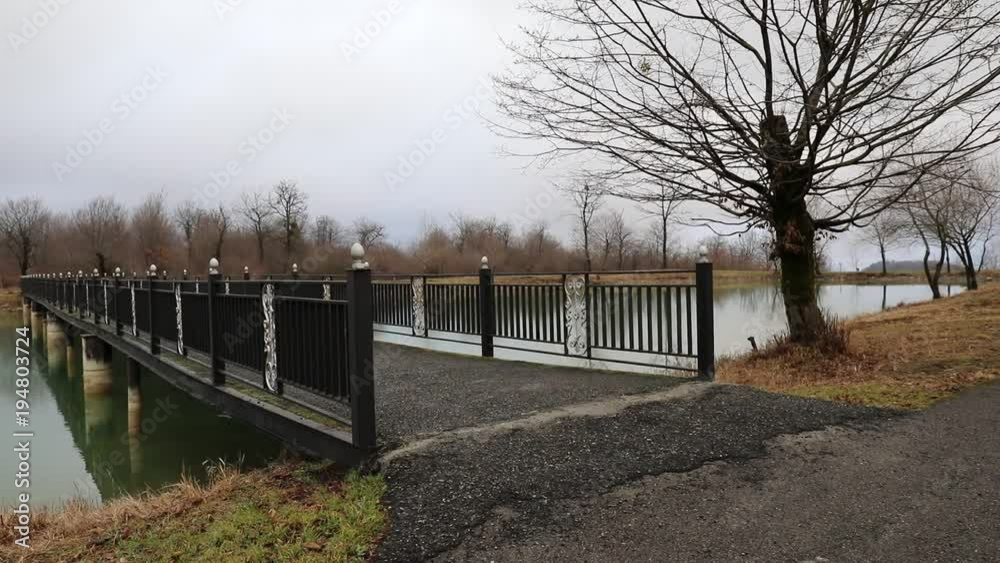 Amazing landscape of bridge reflect on surface water of lake, fog evaporate from pond make romantic scene or Beautiful bridge on lake with trees at fog. Iron bridge over lake in misty morning. Slider Amazing landscape of bridge reflect on surface water of lake, fog evaporate from pond make romantic scene or Beautiful bridge on lake with trees at fog. Iron bridge over lake in misty morning. Slider