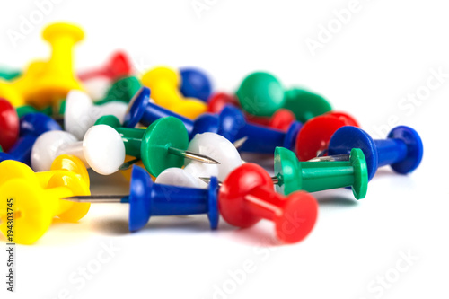 Closeup of Many Colored Thumbtacks on White