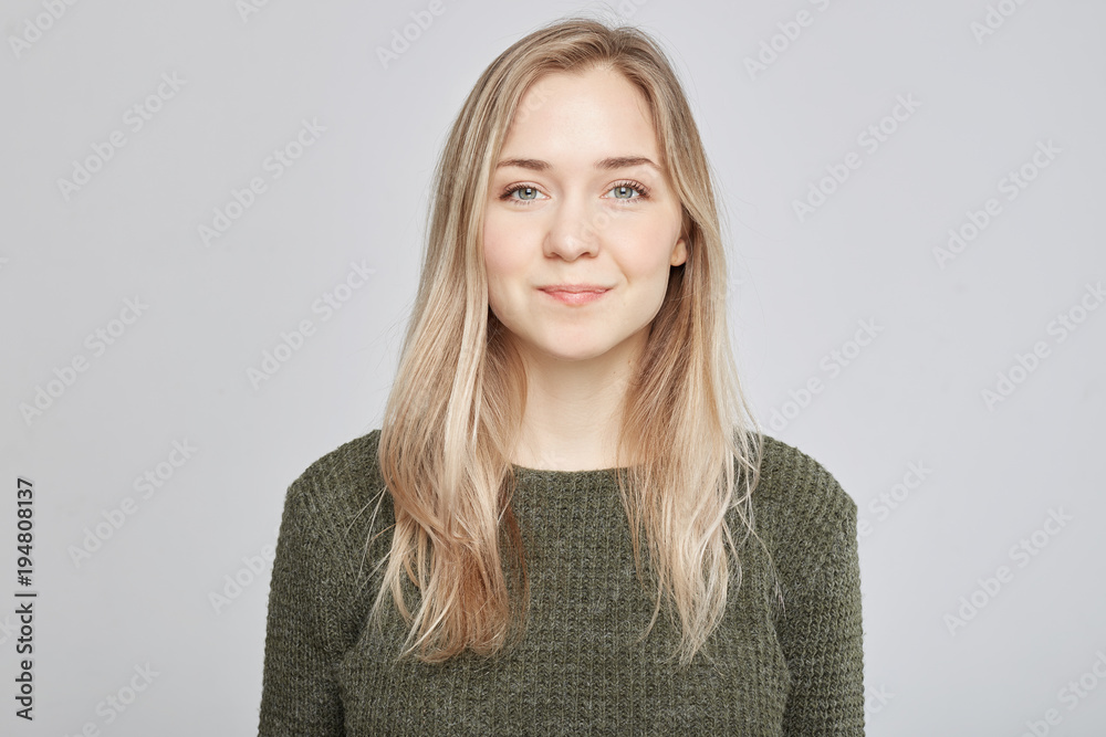 Good looking young Caucasian blond female being glad to hear good news, dressed in casual clothes, poses against white studio background. Happiness and positive emotions concept. Human expressions. Good looking young Caucasian blond female being glad to hear good news, dressed in casual clothes, poses against white studio background. Happiness and positive emotions concept. Human expressions.