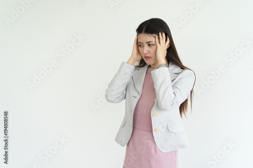 Beautiful asian young business woman having a headache. portrait  on white brick  background © anon