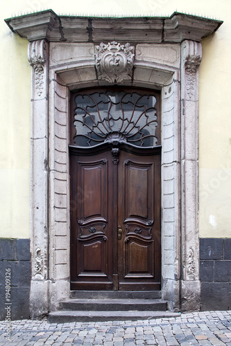 Old wooden doors with stained-glass windows, forged grills and ornaments