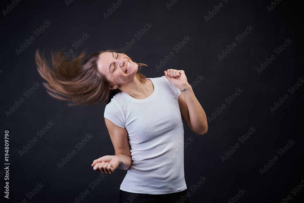 Studio portrait on a black background of a young athletic girl dancing and having fun. Studio portrait on a black background of a young athletic girl dancing and having fun.