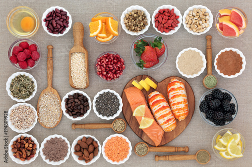 Healthy diet food concept with fresh seafood, fruit, vegetables, pulses, nuts, seeds, grains, dairy, cereals, coffee, nutritional supplement powders and herbs used appetite suppressants. Top view. photo