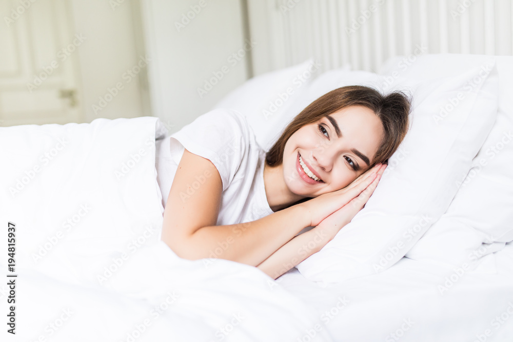 Time to relax. Smiling young woman lying on bed and keeping eyes closed Time to relax. Smiling young woman lying on bed and keeping eyes closed