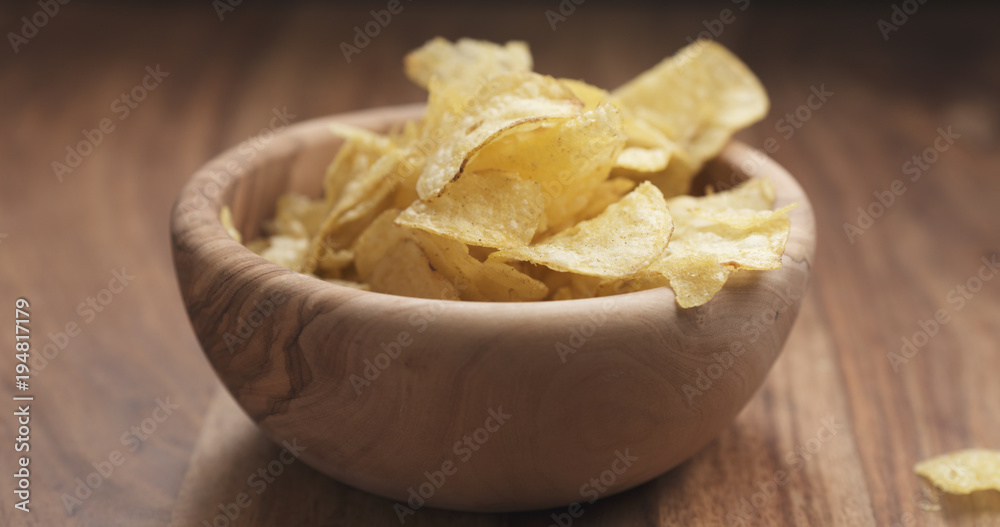 closeup potato chip fall into bowl