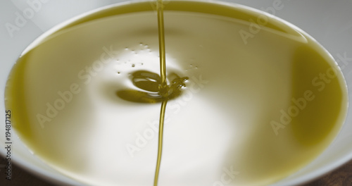pouring olive oil into white plate