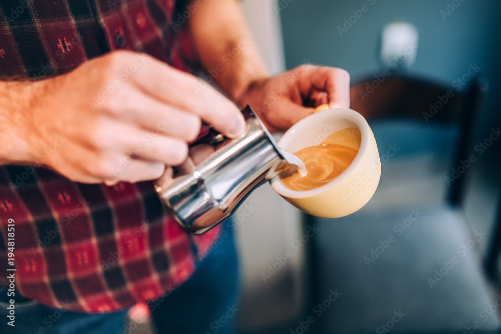Professional barista and bartender pouring latte foam over coffee, espresso and creating a perfect cappuccino Professional barista and bartender pouring latte foam over coffee, espresso and creating a perfect cappuccino
