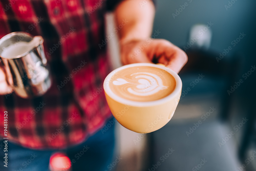 Professional bartender in coffee shop making fresh cappuccino and brewing coffee
