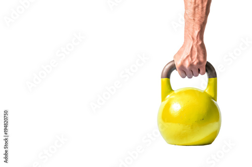 Strong muscular man hand with muscles holding yellow heavy kettlebell partially isolated on white background