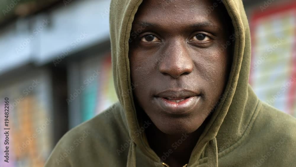Hooded handsome black african man turning and looking camera- Urban background Hooded handsome black african man turning and looking camera- Urban background