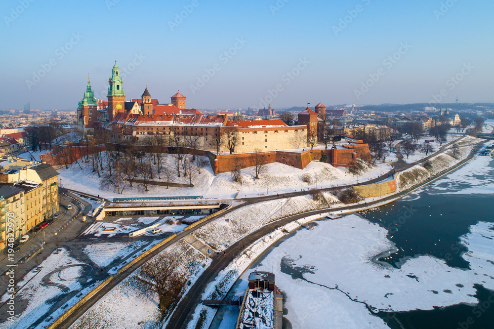 Wawel Castle, Cathedral and partly frozen Vistula river in winter. Krakow, Poland. Aerial skyline in sunset light
