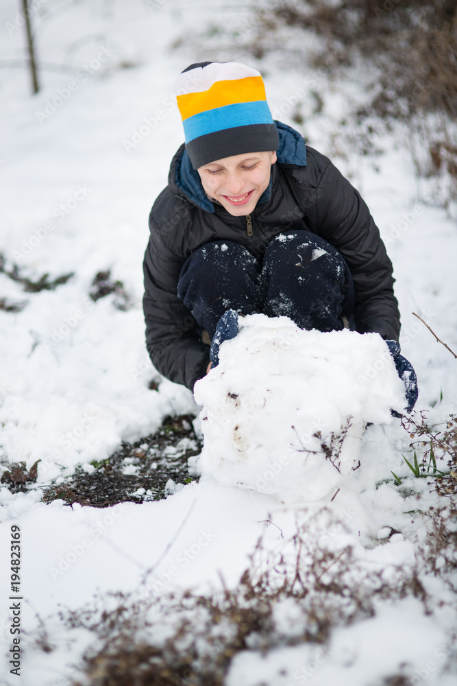 The boy is molded Snowman in the yard in the winter The boy is molded Snowman in the yard in the winter