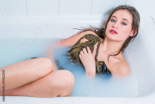     Beautiful young model girl in golden dress in bath  glamour  relaxing  joy  rejuvenation  treatment 