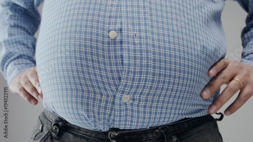 Overweight man in shrt is small to him with huge belly and open buttons