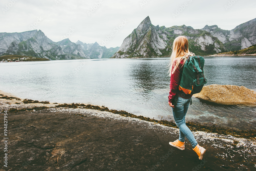 Backpacker woman walking alone in Norway lifestyle travel concept adventure outdoor summer vacations - obrazy, fototapety, plakaty 