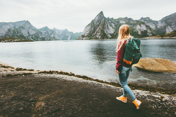 Backpacker woman walking alone in Norway lifestyle travel concept adventure outdoor summer vacations