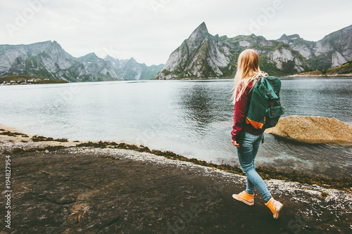 Backpacker woman walking alone in Norway lifestyle travel concept adventure outdoor summer vacations