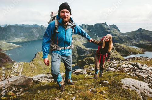 Happy Couple hiking in Norway mountains love and travel holding hands man and woman together Lifestyle concept vacations outdoor