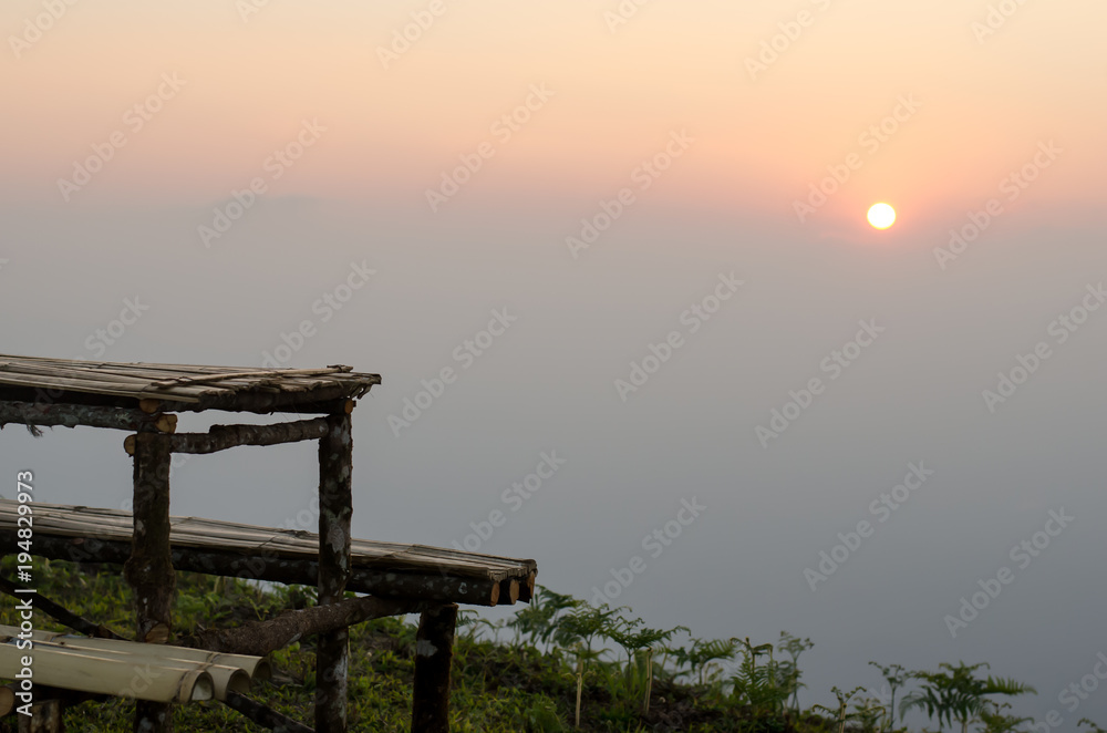 outdoor wooden table and wooden chair with mountain and forest background, bamboo table and bamboo chair, sunset view, natural background
