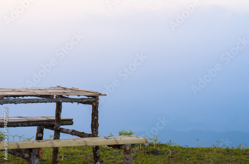 outdoor wooden table and wooden chair with mountain and forest background, bamboo table and bamboo chair, sunset view, natural background