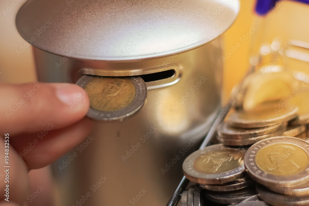 Hand picking coins from a Shopping cart into a coin bank, Saving money concept.