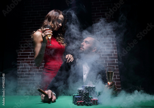 Fototapeta Naklejka Na Ścianę i Meble -  Couple in the casino playing poker on green felt
