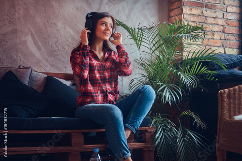 Portrait of a sexy brunette in a flannel shirt and jeans listeni photo