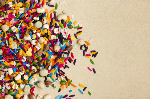 Mixed grains and colorful rice on brown paper background.