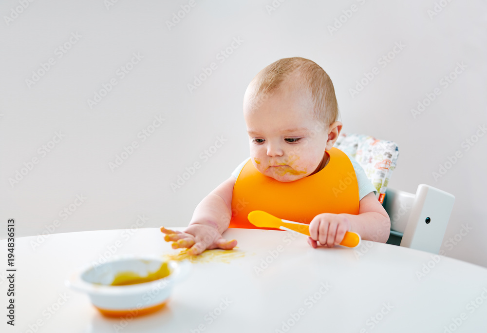 Baby boy with spoon during feeding Baby boy with spoon during feeding