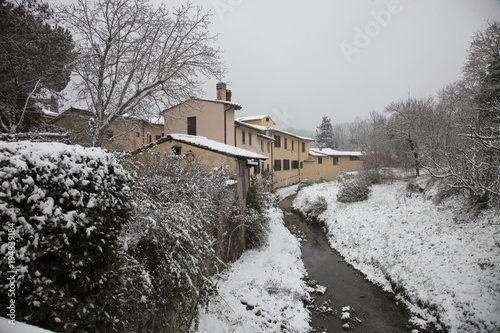 Italia, Toscana, Firenze sotto la neve.Un fiume e case nella campagna toscana.