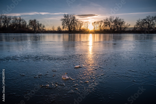 Sun shining through chunks of ice at Riverbend Ponds, Fort Collins, Colorado